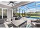 Relaxing screened-in patio with comfortable seating, ceiling fans, and a view of the pool and lush landscaping at 5978 Anise Dr, Sarasota, FL 34238