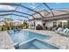 Inviting screened-in pool and hot tub, surrounded by lounge chairs and lush greenery at 5978 Anise Dr, Sarasota, FL 34238