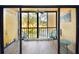A screened outdoor living space with two chairs and table offers a relaxing view of the green space at 625 30Th W Ave # G210, Bradenton, FL 34205