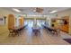 Large community room with tables, chairs, tile floor, and kitchen view at 625 30Th W Ave # G210, Bradenton, FL 34205