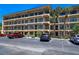 Condominium exterior featuring multiple balconies, parking, and palm trees at 625 30Th W Ave # G210, Bradenton, FL 34205