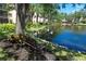 Scenic view of the pond with two swans swimming gracefully, a bench, and community buildings in the distance at 625 30Th W Ave # G210, Bradenton, FL 34205