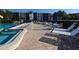 Community pool with white lounge chairs and umbrellas on the deck at 625 30Th W Ave # G210, Bradenton, FL 34205
