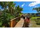 Wood walkway with tropical landscaping leads to condos on a bright, sunny day at 625 30Th W Ave # G210, Bradenton, FL 34205