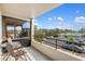 Relaxing balcony featuring tile floors, outdoor seating, and views of the parking area and blue skies at 6415 Midnight Pass Rd # 204, Sarasota, FL 34242