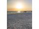 People are relaxing on the beach during sunset at 6415 Midnight Pass Rd # 204, Sarasota, FL 34242