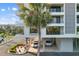 Exterior view of a modern condominium building with covered parking, balconies, and landscaped grounds at 6415 Midnight Pass Rd # 204, Sarasota, FL 34242