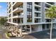 Exterior view of the building featuring multiple stories, balconies, parking and lush landscaping around the property at 6415 Midnight Pass Rd # 204, Sarasota, FL 34242