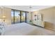 Bright bedroom with a balcony, a dresser with a mirror, and a ceiling fan at 6415 Midnight Pass Rd # 204, Sarasota, FL 34242