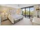 Relaxing primary bedroom with a king bed, soft lighting, and access to a private balcony at 6415 Midnight Pass Rd # 204, Sarasota, FL 34242