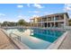 Beautiful community pool and clubhouse featuring numerous chairs and umbrellas for residents' enjoyment at 6415 Midnight Pass Rd # 204, Sarasota, FL 34242