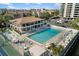Aerial view of community pool and recreation center nestled among lush landscaping and tennis courts at 6415 Midnight Pass Rd # 204, Sarasota, FL 34242