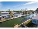 Aerial view of waterfront homes with docks and boat lifts, showcasing canal-front living on a clear day at 654 Jungle Queen Way, Longboat Key, FL 34228