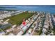An overhead angle captures the canal-front property with the blue home surrounded by lush landscaping at 654 Jungle Queen Way, Longboat Key, FL 34228