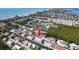 A scenic aerial view reveals the blue home’s location on a canal, with proximity to the beautiful beach at 654 Jungle Queen Way, Longboat Key, FL 34228