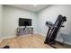 Bright exercise room with a treadmill, wood flooring, and a TV for entertaining workouts at 654 Jungle Queen Way, Longboat Key, FL 34228