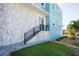 Exterior of elevated coastal home featuring a decorative stone wall, light blue paint, and manicured landscaping at 654 Jungle Queen Way, Longboat Key, FL 34228