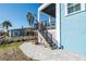 Charming coastal home showcasing a staircase leading to a balcony, complemented by a brick patio at 654 Jungle Queen Way, Longboat Key, FL 34228