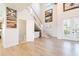 View of the foyer featuring a staircase with glass railing, under-stair bar, and adjacent powder room at 654 Jungle Queen Way, Longboat Key, FL 34228