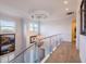 Bright hallway with glass railing, chandelier, and wood look flooring at 654 Jungle Queen Way, Longboat Key, FL 34228