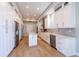 Modern kitchen with white cabinets, stainless steel appliances, and a marble-topped island at 654 Jungle Queen Way, Longboat Key, FL 34228