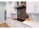 Gourmet kitchen featuring sleek countertops, stainless steel range hood, and modern backsplash at 654 Jungle Queen Way, Longboat Key, FL 34228