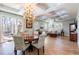 Open-concept living and dining area with a decorative chandelier and natural light at 654 Jungle Queen Way, Longboat Key, FL 34228