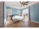 Bright main bedroom with ceiling fan, backyard view, and wood look flooring at 654 Jungle Queen Way, Longboat Key, FL 34228