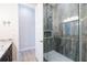 Shower boasts modern design with glass door and gray tile, adjacent to a granite vanity at 654 Jungle Queen Way, Longboat Key, FL 34228