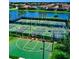 Aerial view of tennis courts, a basketball court and a pond surrounded by homes at 6914 Grand Estuary Trl # 101, Bradenton, FL 34212