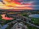 Breathtaking aerial view of the community featuring a lake and homes during a vibrant sunset at 6914 Grand Estuary Trl # 101, Bradenton, FL 34212