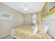 Bright bedroom with white furniture, yellow patterned bedspread, and coastal themed decor at 6914 Grand Estuary Trl # 101, Bradenton, FL 34212