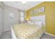 Cozy bedroom featuring a queen-sized bed, bright yellow accent wall, and a ceiling fan at 6914 Grand Estuary Trl # 101, Bradenton, FL 34212
