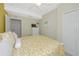 Inviting bedroom featuring a yellow bedspread, dresser, and closet space at 6914 Grand Estuary Trl # 101, Bradenton, FL 34212