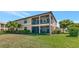Inviting exterior view of a two-story home with dual screened lanais, lush landscaping, and a well-manicured lawn at 6914 Grand Estuary Trl # 101, Bradenton, FL 34212