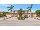Inviting exterior of a townhome with paver driveway, mature palms, and a two-car garage at 6914 Grand Estuary Trl # 101, Bradenton, FL 34212