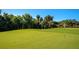 Expansive green golf course putting area surrounded by lush, mature trees at 6914 Grand Estuary Trl # 101, Bradenton, FL 34212