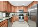 Modern kitchen featuring stainless steel appliances, granite countertops, and wood cabinets at 6914 Grand Estuary Trl # 101, Bradenton, FL 34212