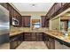 Kitchen with dark cabinets, stainless steel appliances, granite countertops and tile flooring at 6914 Grand Estuary Trl # 101, Bradenton, FL 34212