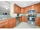 Bright kitchen with wood cabinets, granite countertops, and stainless steel appliances at 6914 Grand Estuary Trl # 101, Bradenton, FL 34212