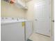 Efficient laundry room with washer, dryer, and shelving storage at 6914 Grand Estuary Trl # 101, Bradenton, FL 34212