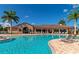 Resort-style community pool with lounge chairs, palm trees, and a clubhouse on a sunny day at 6914 Grand Estuary Trl # 101, Bradenton, FL 34212