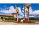Welcoming entrance to tennis courts with lush landscaping and towering palm trees at 6914 Grand Estuary Trl # 101, Bradenton, FL 34212