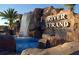 Entrance to River Strand community featuring a beautiful waterfall, adding a touch of nature and tranquility to the surroundings at 6914 Grand Estuary Trl # 101, Bradenton, FL 34212