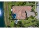 Aerial view of a home with a pool, manicured lawn, and backing onto a lake at 7218 Teal Creek Gln, Lakewood Ranch, FL 34202