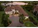 Luxurious home with a circular driveway, tile roof, and lush landscaping, nestled on a golf course with serene lake views at 7218 Teal Creek Gln, Lakewood Ranch, FL 34202