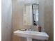 Elegant half bathroom features stylish sink with designer mirror and faux-crocodile wall texture at 7218 Teal Creek Gln, Lakewood Ranch, FL 34202