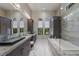 Modern bathroom featuring a soaking tub, frameless shower, granite counters and dual vanities at 7218 Teal Creek Gln, Lakewood Ranch, FL 34202