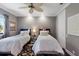 This warm and inviting bedroom features two twin beds with a floral accent rug at 7218 Teal Creek Gln, Lakewood Ranch, FL 34202