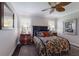 A cozy bedroom features a floral comforter and abundant natural light from shuttered windows at 7218 Teal Creek Gln, Lakewood Ranch, FL 34202